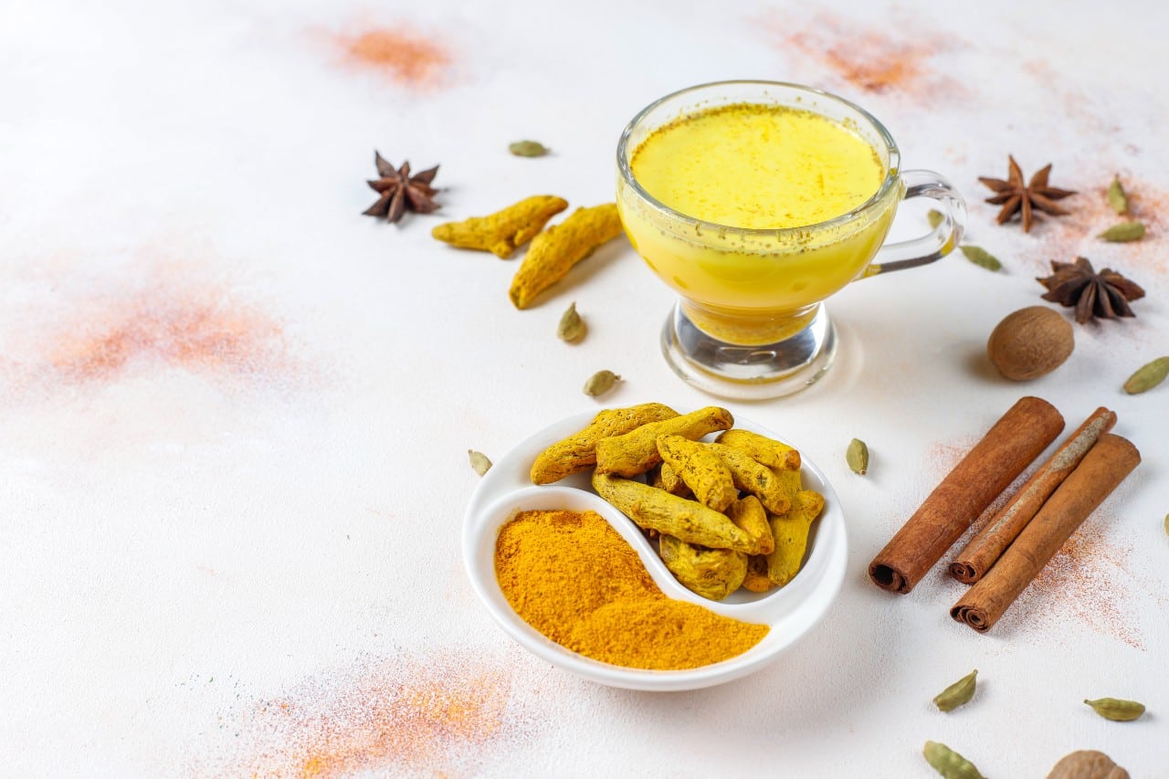 Drink made of turmeric with spices in the background