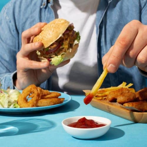 Person Eating a Burger Meal with Fries and Ketchup