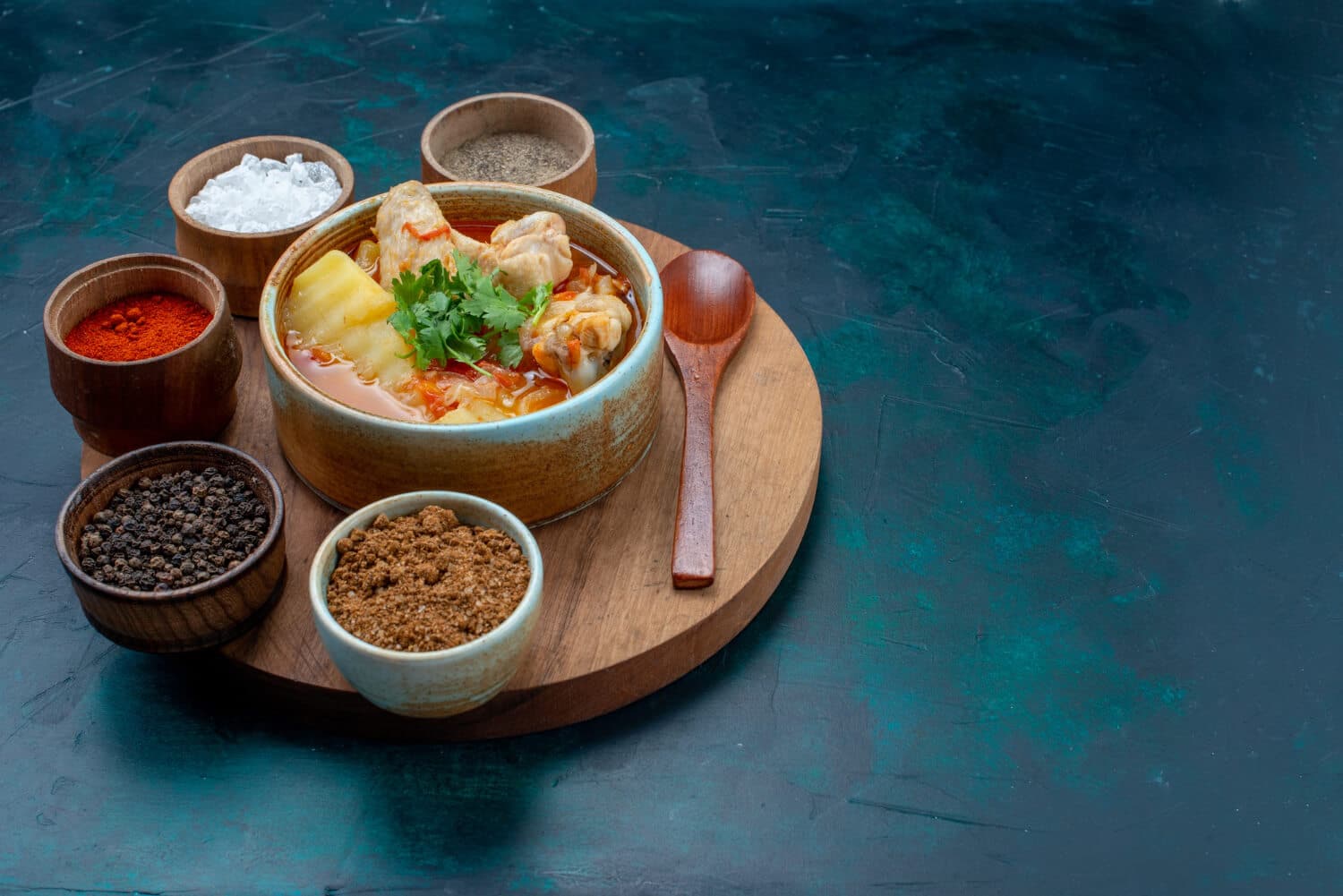 Which 25 Singapore Food Dishes Should You Try? 1 A bowl of chicken and potato stew garnished with cilantro served on a wooden board alongside various spices