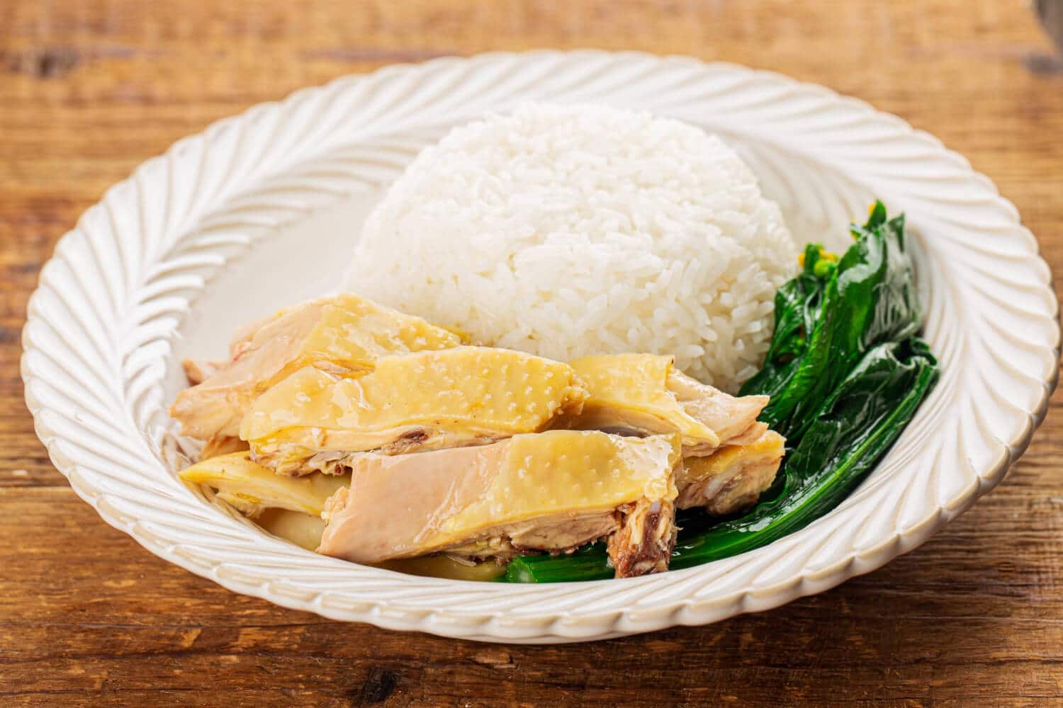 Which 25 Singapore Food Dishes Should You Try? 2 A plate of Hainanese chicken rice featuring sliced poached chicken