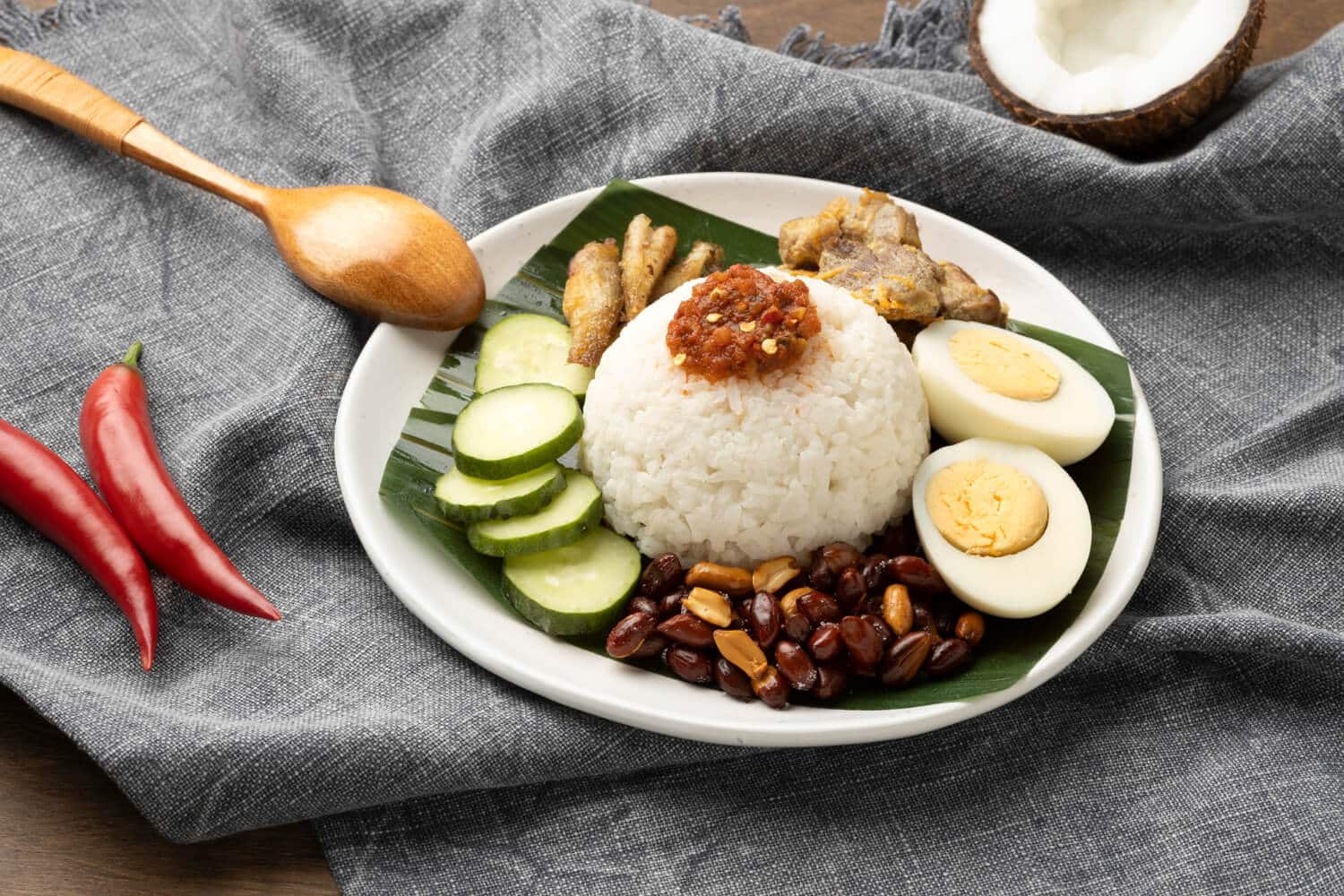 Which 25 Singapore Food Dishes Should You Try? 8 A plate of Nasi Lemak featuring a dome of coconut rice topped with sambal