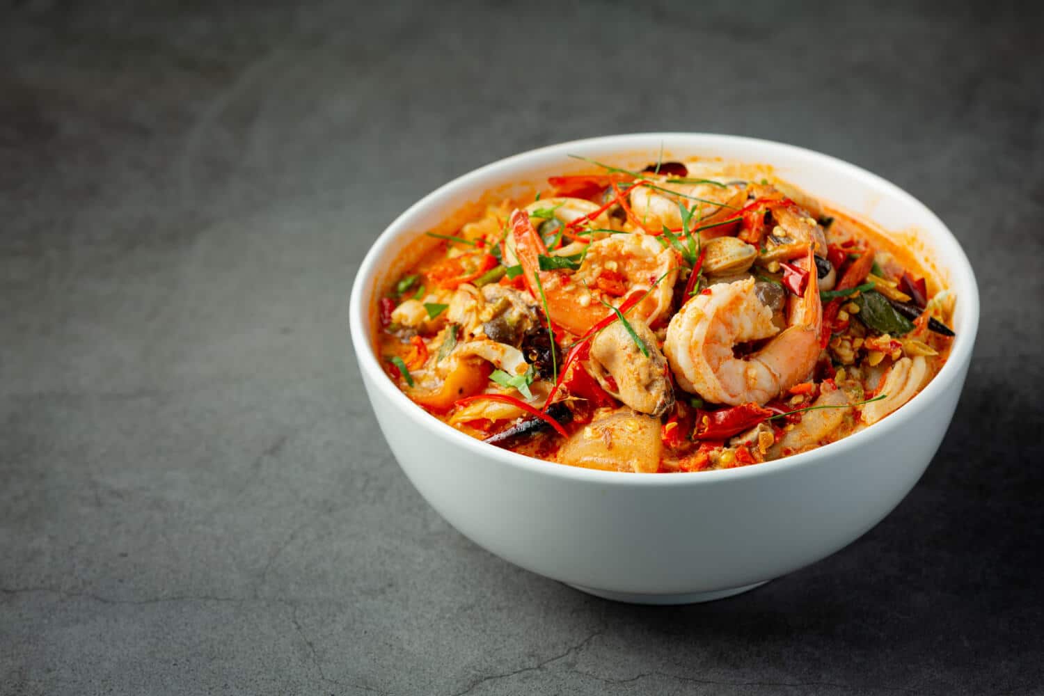 Which 25 Singapore Food Dishes Should You Try? 3 A white bowl filled with spicy Tom Yum Goong soup