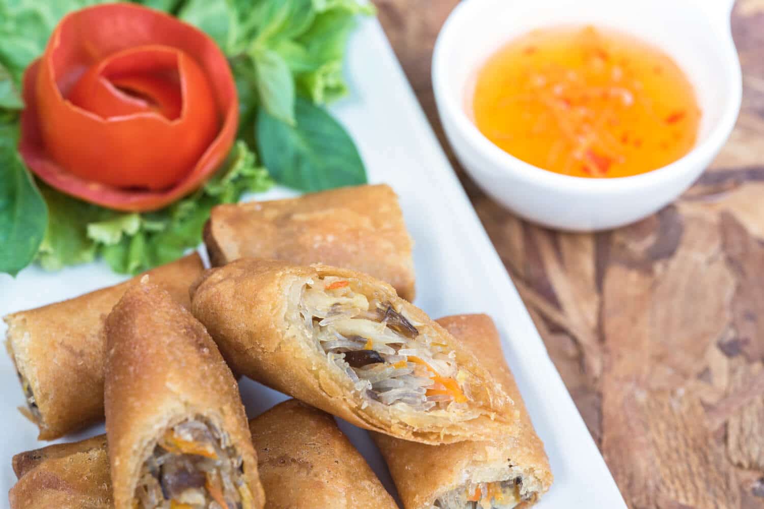 Which 25 Singapore Food Dishes Should You Try? 17 Crispy golden brown spring rolls one sliced open to reveal a vegetable and glass noodle filling
