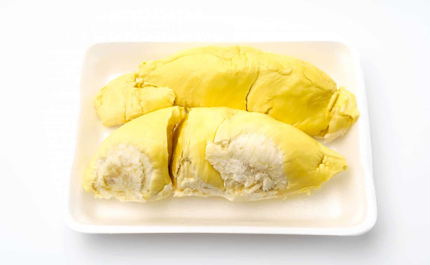 Which 25 Singapore Food Dishes Should You Try? 21 Three large segments of bright yellow ripe durian flesh arranged in a white styrofoam tray