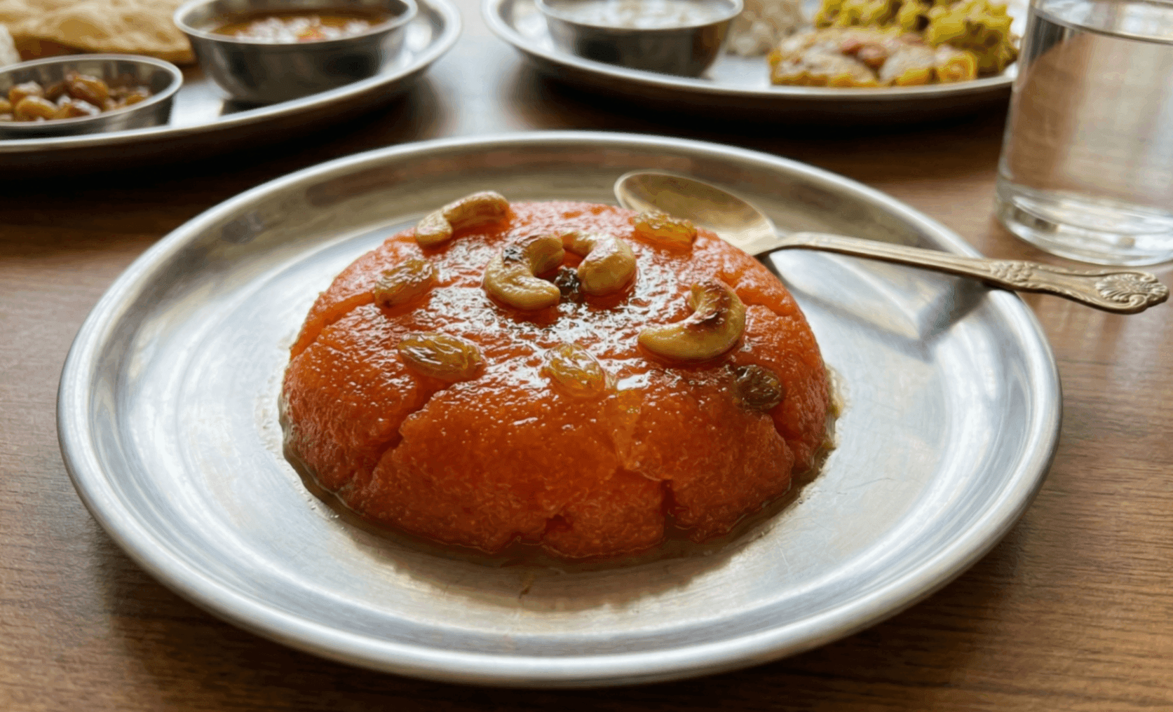 What Are the 15 Traditional Tamil New Year Dishes You Must Try? 11 Kesari semolina sweet with ghee cashews and raisins served on plate as Tamil New Year dessert