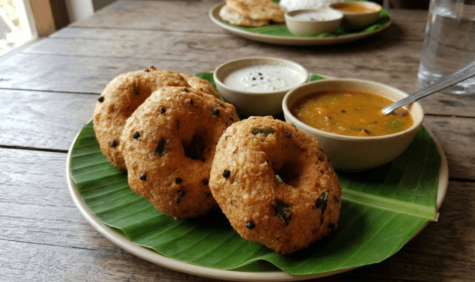 What Are the 15 Traditional Tamil New Year Dishes You Must Try? 8 Medhu vada crispy lentil fritters served with sambar and coconut chutney on banana leaf