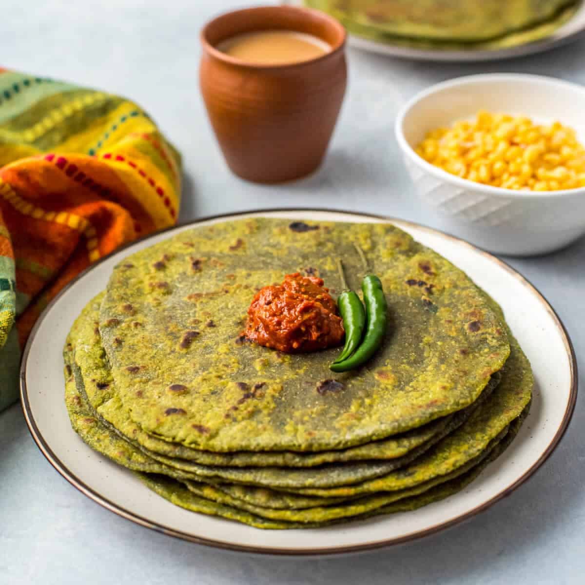 What are the Top Spinach Benefits for Health? 4 Spinach paratha cooked on a tawa with green flatbread texture and served hot