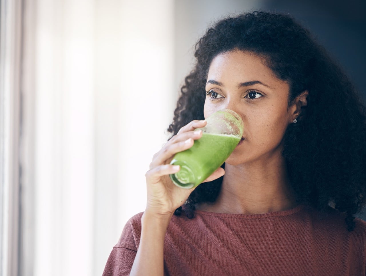 A woman drinking healthy green juice