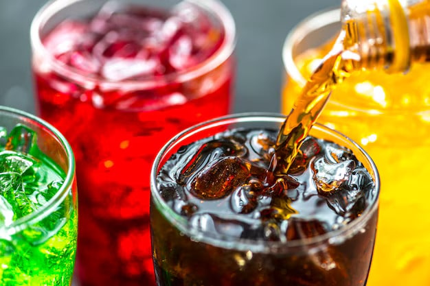 Colourful sugary drinks in glasses with ice