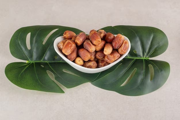 Bowl of dried dates on green leaves