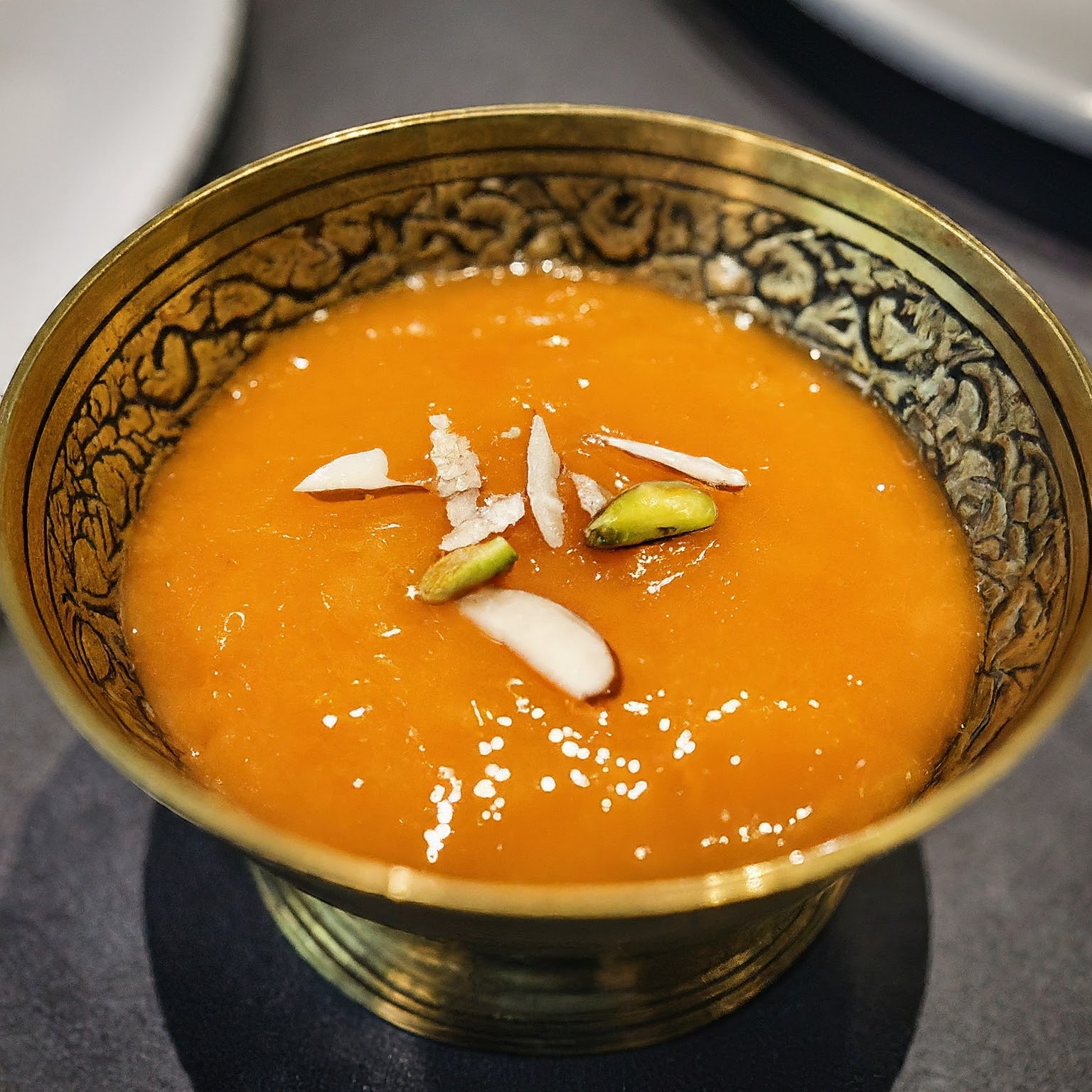 A close-up view of a bowl of Aamras, a thick and creamy Indian mango puree dessert.