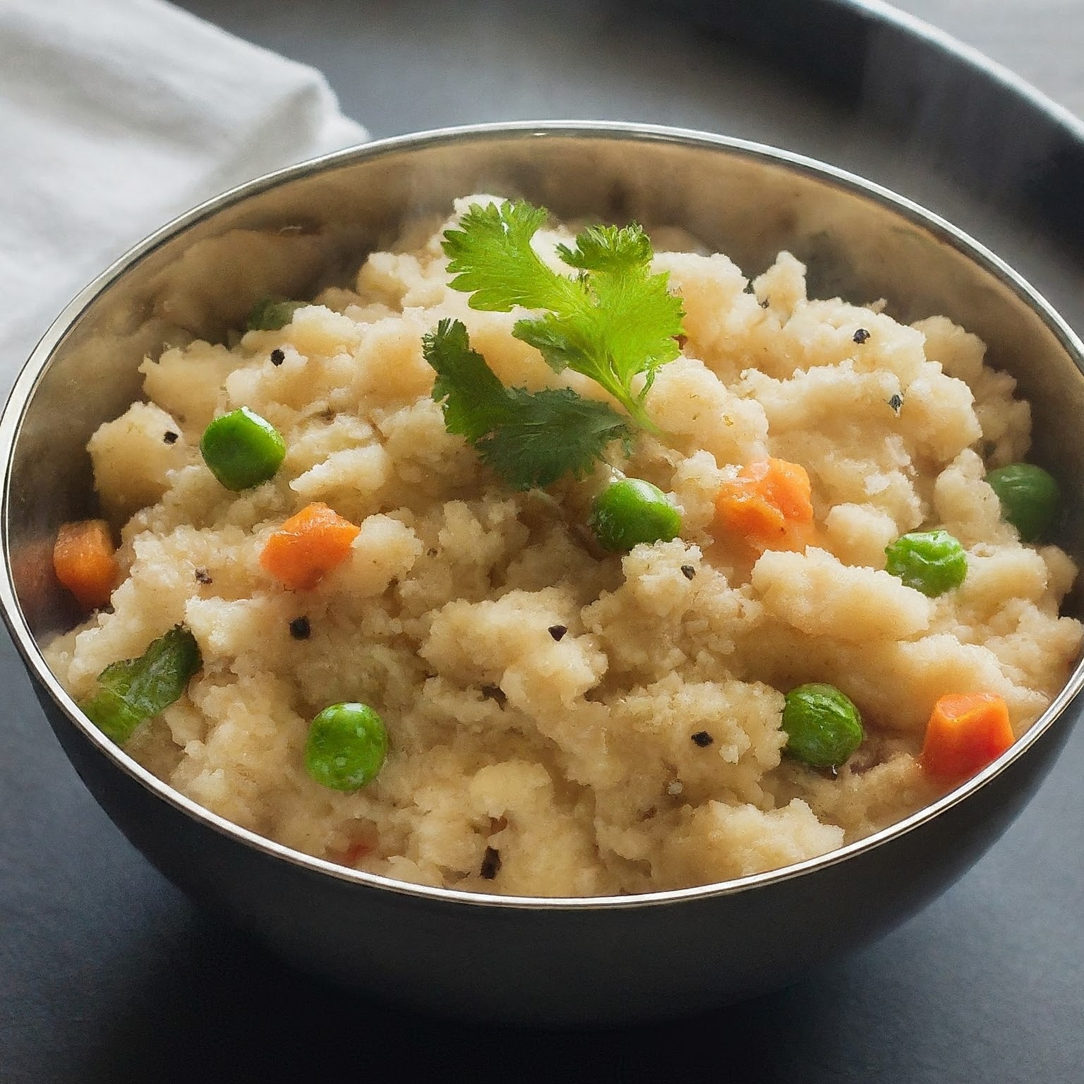 Steaming bowl of Rava Upma, a South Indian breakfast dish with semolina, vegetables, and spices.