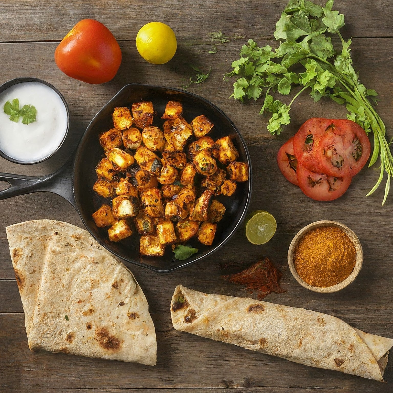 Recipe spread for Spicy Paneer Tikka Wrap with ingredients on a wooden table.