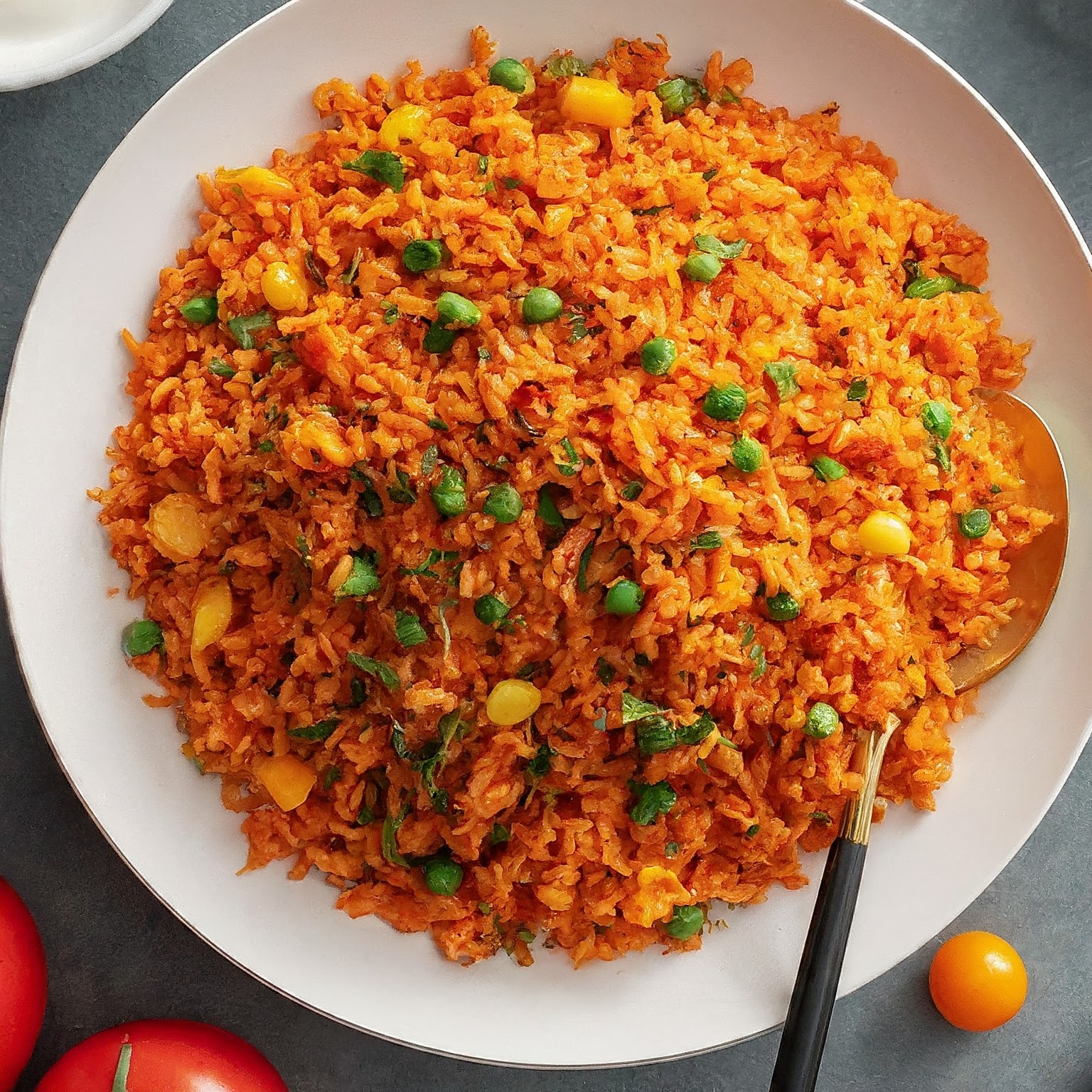 Plate of Spicy Tomato Rice with fluffy red rice, vegetables, and spices.