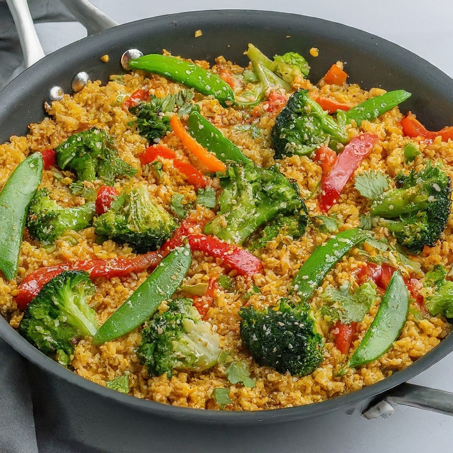 Filled with Sweet and Spicy Millet Stir-Fry with colourful vegetables, a sweet and spicy sauce, and sesame seeds.