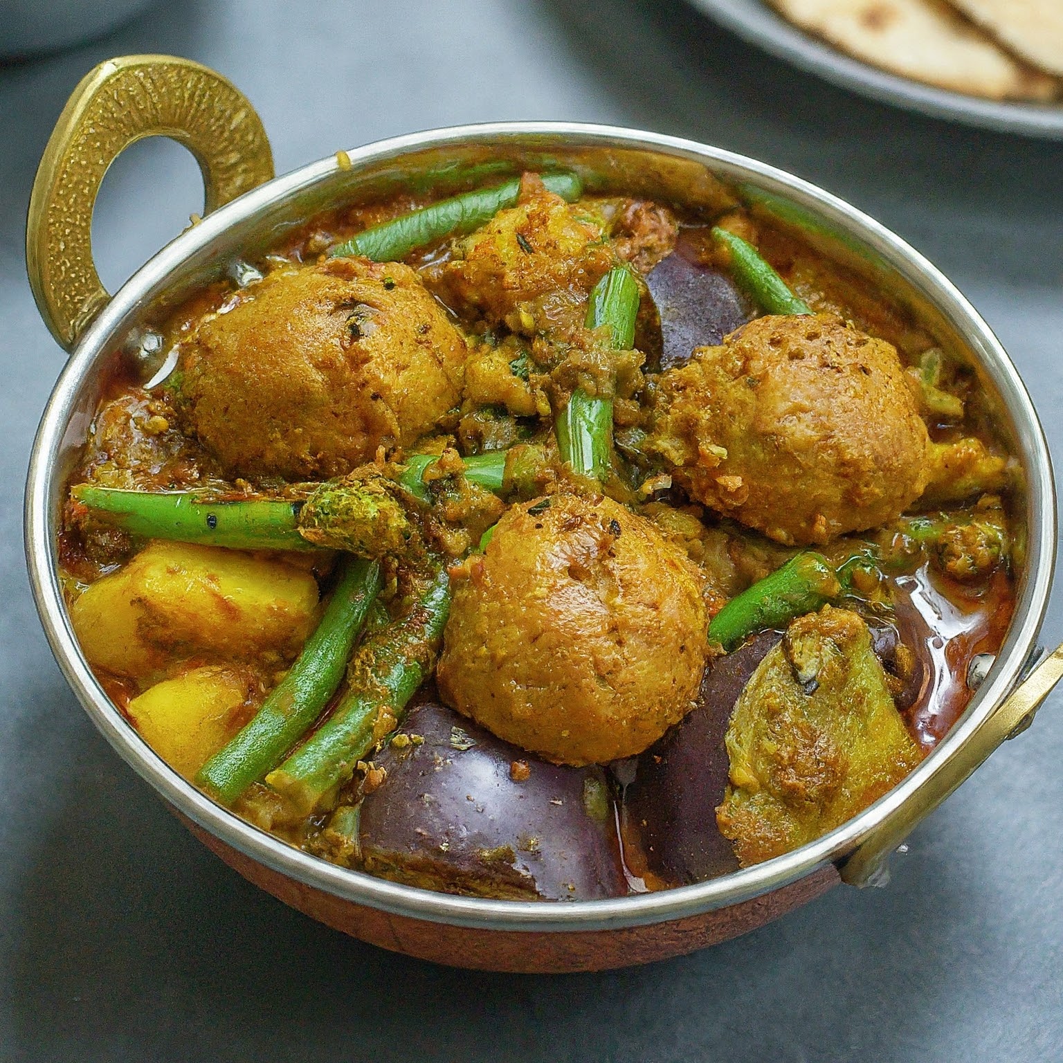 A colourful bowl of Undhiyu, a Gujarati vegetable curry with seasonal vegetables and dumplings.