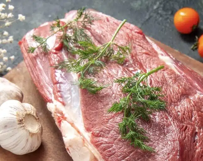 lean beef and garlic on a chopping board 