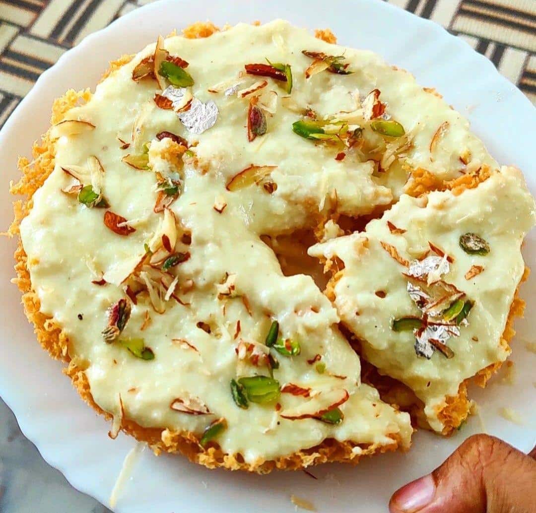What Are the Most Popular Rajasthan Famous Food Dishes? 7 Ghewar traditional Rajasthani festive dessert with honeycomb texture topped with rabri and dry fruits