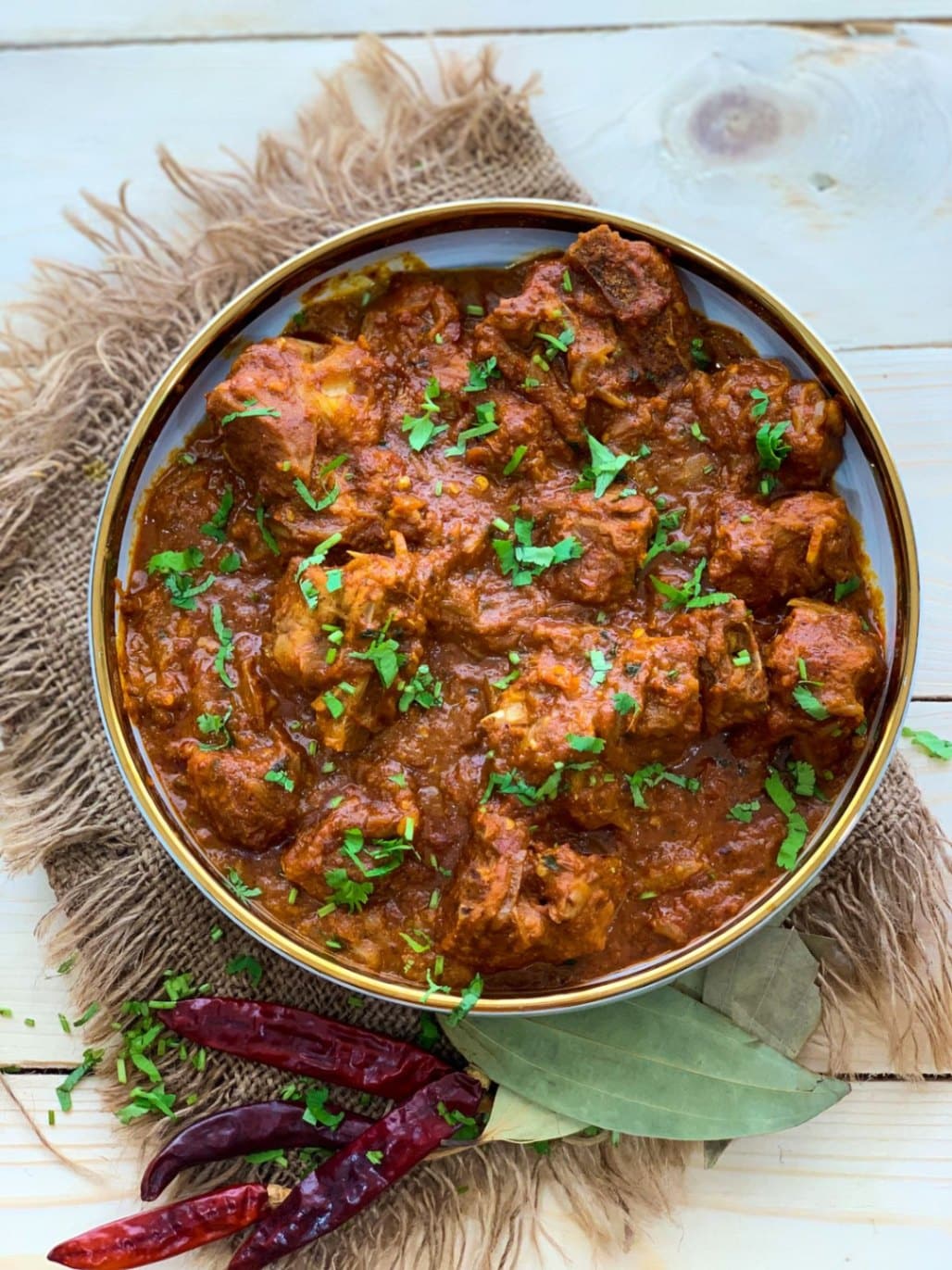 What Are the Most Popular Rajasthan Famous Food Dishes? 2 Laal Maas spicy Rajasthani mutton curry with rich red gravy served in a traditional bowl