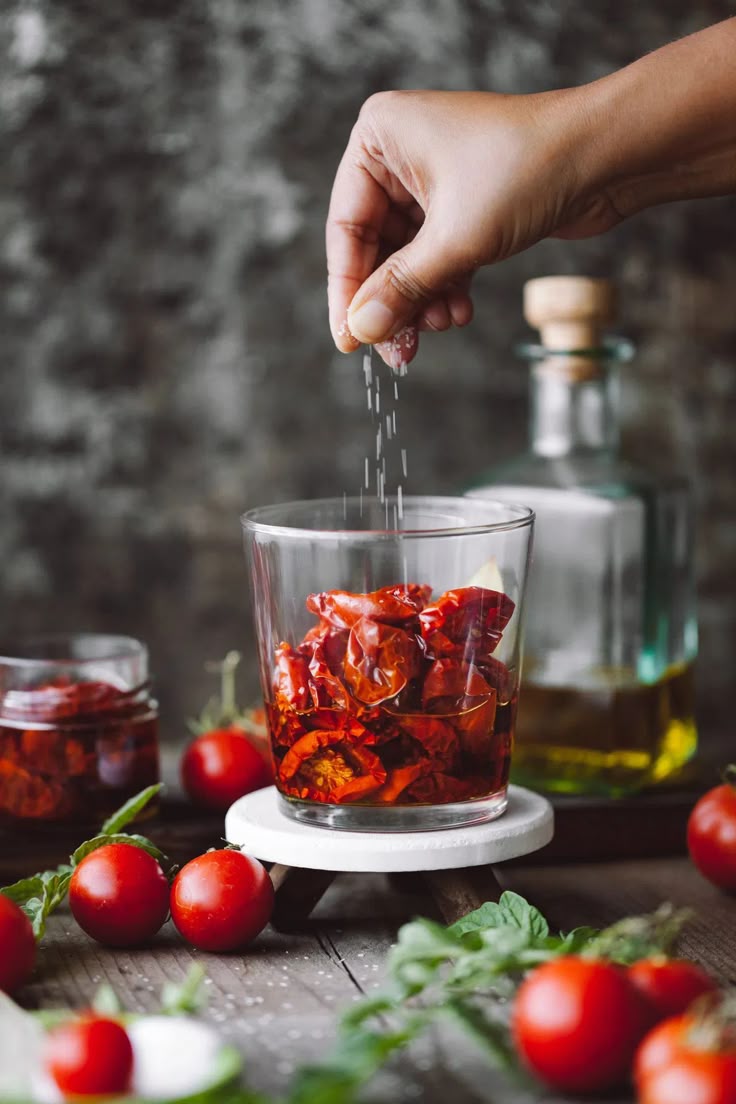 A jar of red tomatoes sprinkled with salt