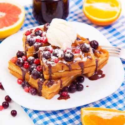 Belgian waffles with a topping of berries and whipped cream