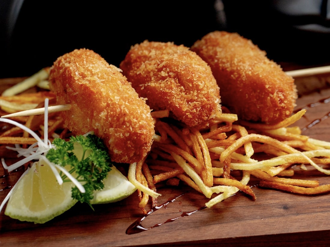 cutlets lemon and fritters on a wooden tray