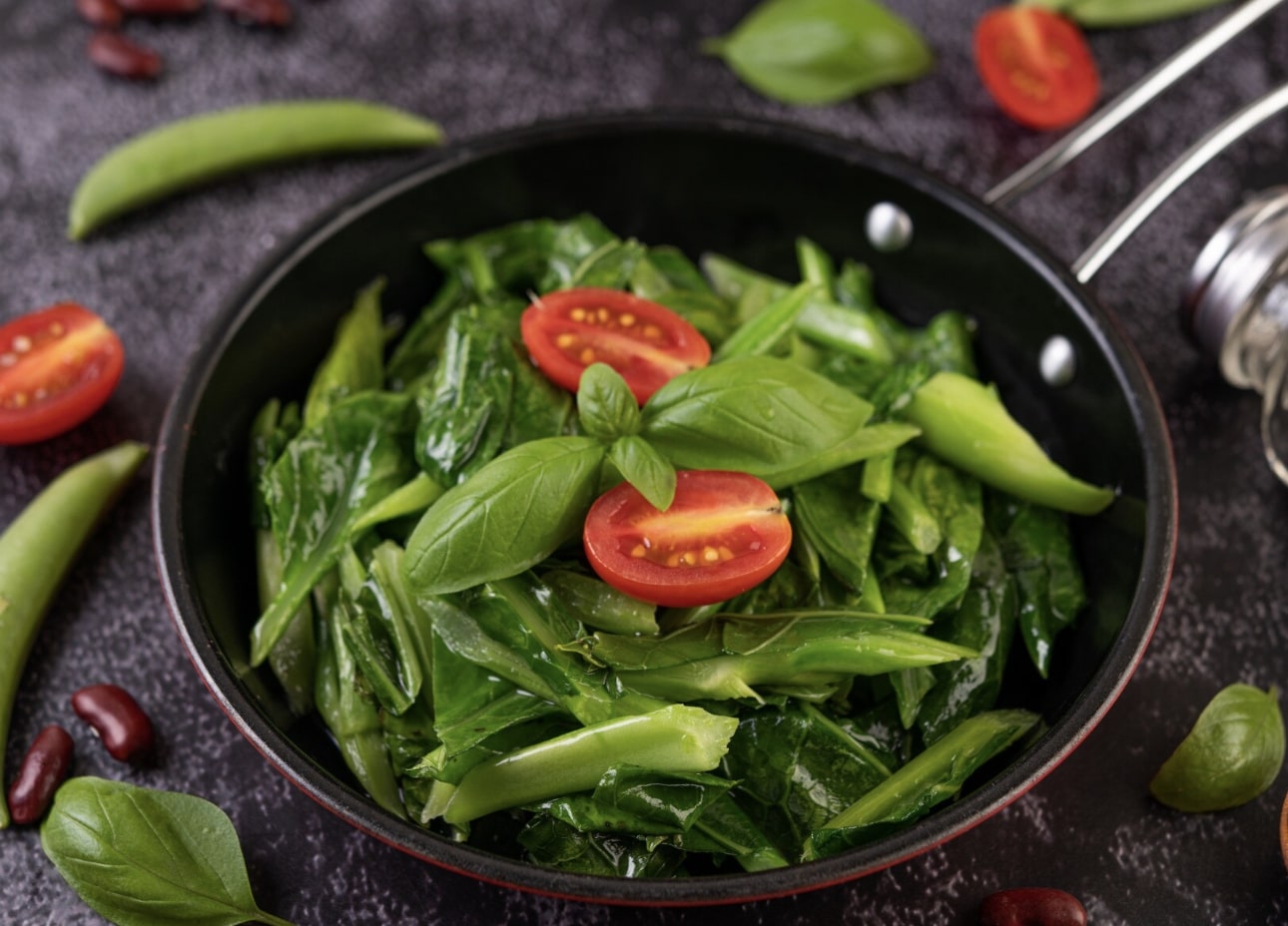 spinach kale and tomatoes in a pan 