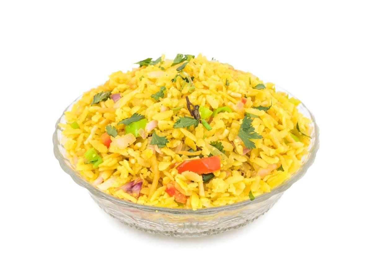 What are the 10 Best Ideas for Cooking Without Fridge? 3 A bowl of Poha a flattened rice dish garnished with fresh coriander onions and tomatoes