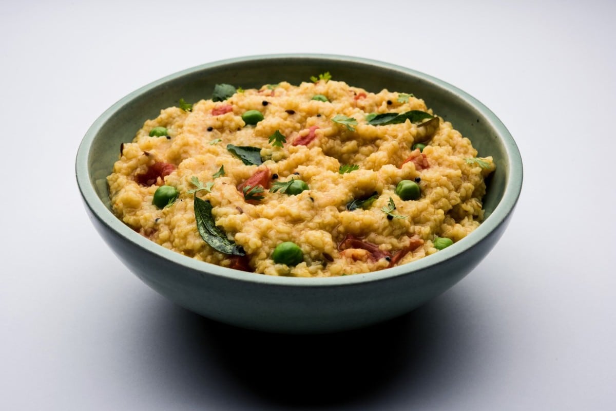 A bowl of masala oats upma cooked with vegetables curry leaves and spices showcasing a hearty and colourful Indian breakfast dish