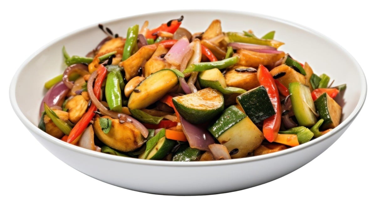A bowl of mixed vegetable stir fry with colourful peppers onions zucchini and mushrooms tossed in light seasoning