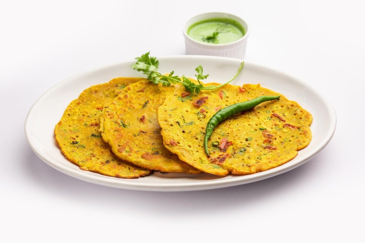 What are the 10 Best Ideas for Cooking Without Fridge? 10 A plate of Besan Chilla chickpea flour pancakes garnished with fresh coriander leaves and a green chili served with a side of green chutney