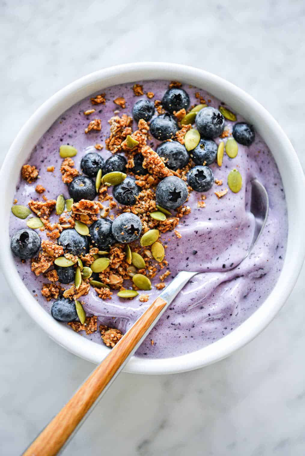 How to Make Smoothies at Home With Simple Ingredients? 1 Blueberry smoothie bowl topped with fresh berries granola and coconut flakes