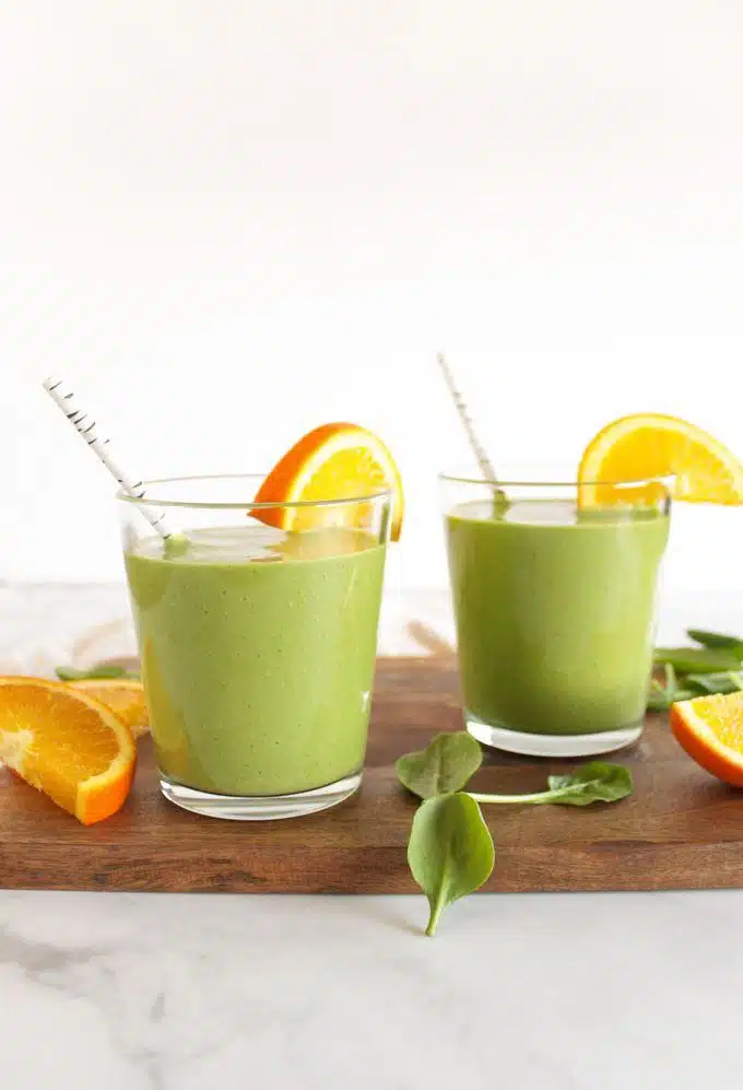 What Are the Benefits of Smoothies and Juices for Health? 1 Spinach and orange juice smoothie served in a glass with fresh spinach and orange slices