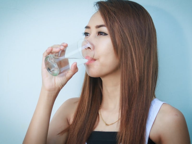 Which 10 Instant Hangover Cure Tips Should You Try Today? 2 Young woman sipping water from a clear glass